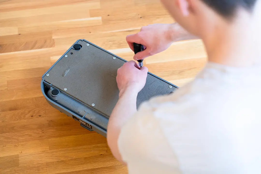 Upturned braille writer having its base unscrewed.