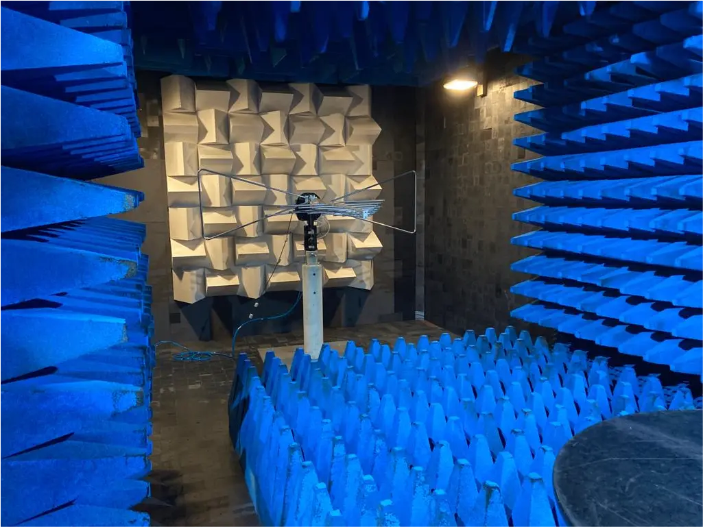 Blue anechoic chamber with antenna for CE and UKCA regulatory testing.