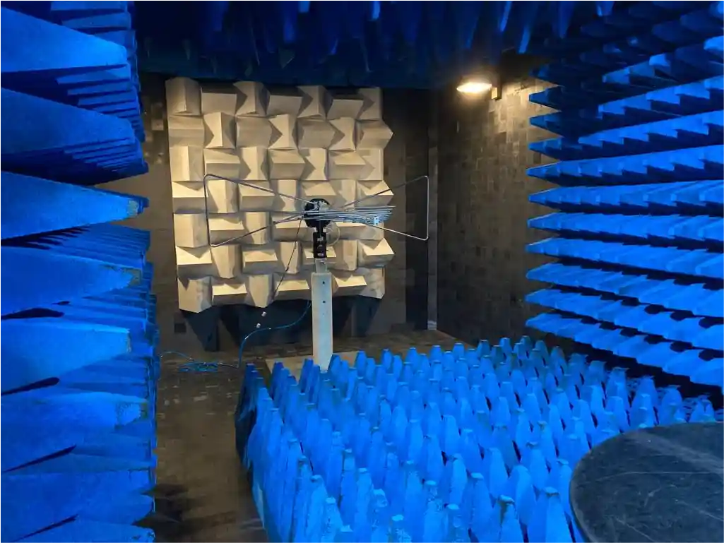 Blue anechoic chamber with antenna for CE and UKCA regulatory testing. 